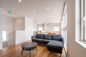 a living room with a couch and a table at Soga House in Niseko