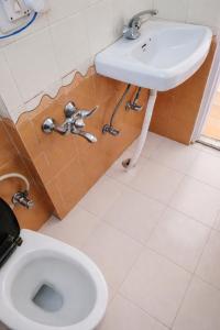 a bathroom with a sink and a toilet at Apple Garden Aleo in Manāli