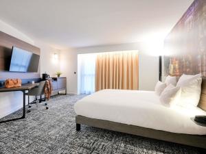 a hotel room with a large bed and a desk at Novotel Paris Centre Bercy in Paris