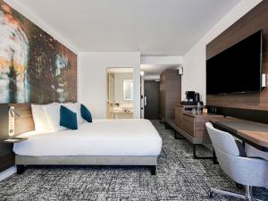 a hotel room with a bed and a desk at Novotel Paris Centre Bercy in Paris +125 photos