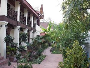 a walkway in front of a building with plants at Villa Saykham in Luang Prabang