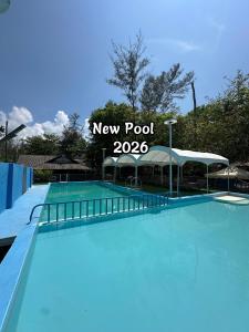 a swimming pool with a new pool sign at Kembara Resort, Merang in Setiu