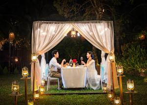 a bride and groom sitting at a table under a tent at Sen Village Hoi An in Hoi An +135 photos
