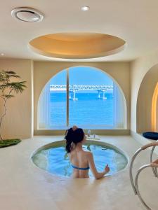 a girl in a bath tub in a room with a bridge at Meomulda Subyeon in Busan