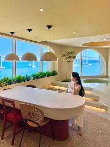 a woman is standing in a room with a table at Meomulda Subyeon in Busan