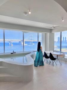 a woman sitting in a room with a view of a bridge at Meomulda Subyeon in Busan +71 photos