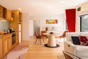 a kitchen and living room with a table and a couch at Studio 216 - Oceanview Studio with Bath, Romantic Bruny Escape in Alonnah