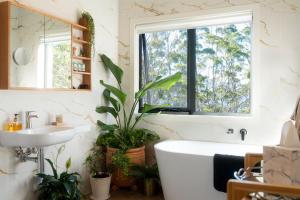 a bathroom with a tub and a sink and a window at Studio 216 - Oceanview Studio with Bath, Romantic Bruny Escape in Alonnah +27 photos