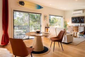 a living room with a table and a surfboard on the ceiling at Studio 216 - Oceanview Studio with Bath, Romantic Bruny Escape in Alonnah