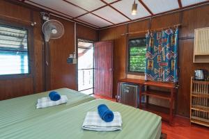 a bedroom with two beds with towels and a desk at Tao Thong Villa 2 in Ko Tao