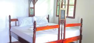a bedroom with a bed with white sheets and two windows at The Twende Villa on Beach in Paje