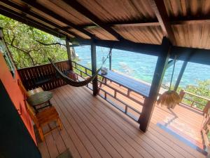 a porch with a hammock and a view of the ocean at Tao Thong Villa 2 in Ko Tao