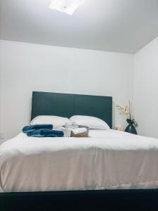 a bed with white sheets and two books on it at Saffire Villa Rooms in Tacoma