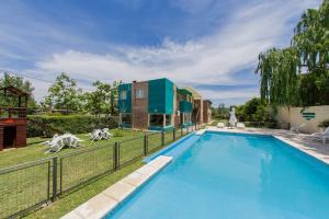 a swimming pool in front of a house at Complejo Turístico Las Catalpas in Mina Clavero