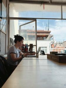 a woman sitting at a table with a laptop computer at Theodora Hostel in Istanbul