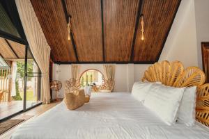a bedroom with a large bed with a wooden ceiling at นวนิยาย Nava-Niyay in Ban Huai Ti
