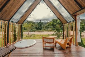 a bathroom with a tub and a chair on a deck at นวนิยาย Nava-Niyay in Ban Huai Ti