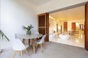 a dining room with a table and a mirror at Luxury Beachfront Stay - 5 Pools! in Careyes
