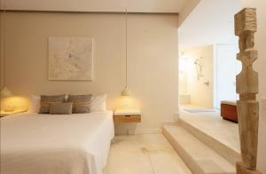 a bedroom with a white bed and a bathroom at Luxury Beachfront Stay - 5 Pools! in Careyes