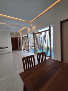 a dining room with a wooden table and two chairs at Villa Luck Canggu Bali unit 8 in Canggu