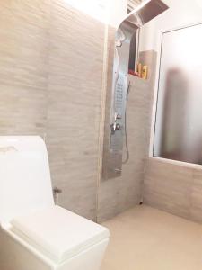 a bathroom with a toilet and a phone next to a tv at The white house in Kelaniya +31 photos