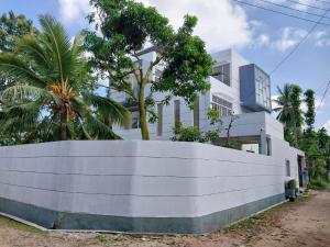 a white fence in front of a white building at The white house in Kelaniya