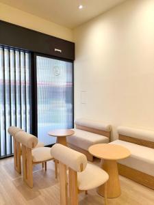 a waiting room with tables and chairs and windows at 逢甲25行館Fengjia 25 Hotel in Taichung