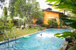 a person in a swimming pool with a frisbee at KuTÓN ECOCAMP in Lương Sơn