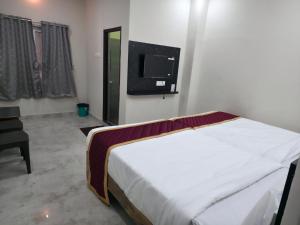 a bedroom with a bed and a tv on the wall at RK Residency in Tirupati