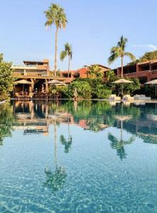 a pool of water with palm trees and a building at Luxury Beachfront Stay - 5 Pools! in Careyes