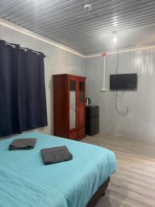 a room with a bed and a tv and a bed sidx sidx sidx at Stella'z guesthouse in Siquijor