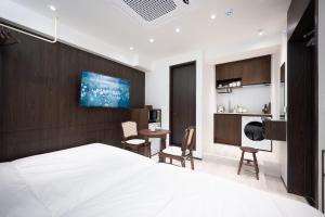 a bedroom with a white bed and a living room at ryeoan seomyeon in Busan