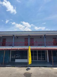 a building with a yellow sign in front of it at D'Aleena Inn Kodiang in Kodiang