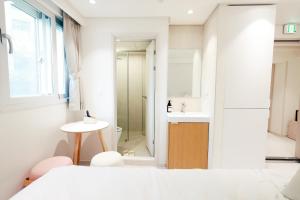 a white bathroom with a toilet and a sink at 더 신촌스테이 레지던스 in Seoul +92 photos