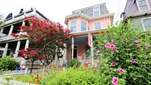 a pink house with flowers in front of it at Cottage At 37 Jackson in Cape May