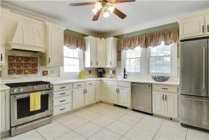 a kitchen with white cabinets and a ceiling fan at The Cape May Diamond in Cape May