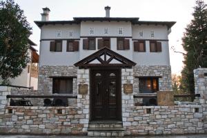 a stone house with a door on a wall at Εποχές στη Βυζίτσα in Vyzitsa