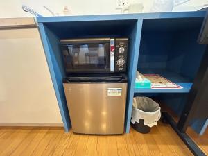 a microwave sitting on top of a trash can under a desk at Exsaison SETOUCHI in Sakaide