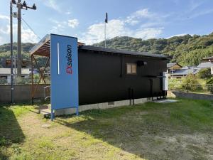 a black building with a sign in front of it at Exsaison SETOUCHI in Sakaide