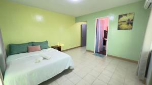 a bedroom with a white bed with a pink pillow at Bantayan Beachfront Seacamp Okoy Private House Operated by In Dai Aquasports and Beach Resort in Bantayan Island