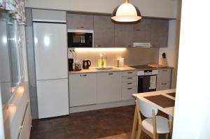 a kitchen with white cabinets and a white refrigerator at Apartment Skylights in Rovaniemi +10 photos