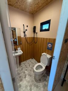 a bathroom with a shower and a toilet and a sink at Tavana Residence in Ban Na Bon