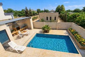 a swimming pool on a patio next to a house at Villa Fratello in Baku