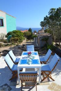 a table with four chairs and a table with flowers on it at Casa Vacanze Miranda in Torre Dei Corsari