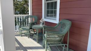 a porch with three chairs and a table on a house at Sail Away in Cape May Point