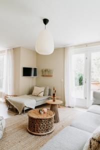 a living room with a couch and a table at Bohemian Wellness met hottub & sauna in Ewijk