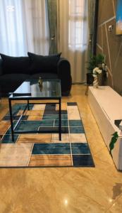 a living room with a glass coffee table on a wooden floor at Malaika homes in Kampala