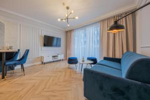 a living room with a blue couch and a table at Azure Mostek Oldtown in Gdańsk