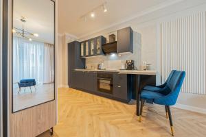 a kitchen with a blue chair and a table at Azure Mostek Oldtown in Gdańsk