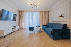 a living room with a blue couch and a tv at Azure Mostek Oldtown in Gdańsk +12 photos